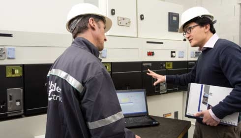 Deux techniciens de Schneider discutant à côté d’un ordinateur