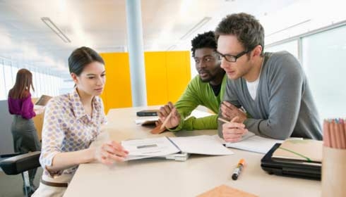 Trois collègues d’affaires discutant de documents techniques