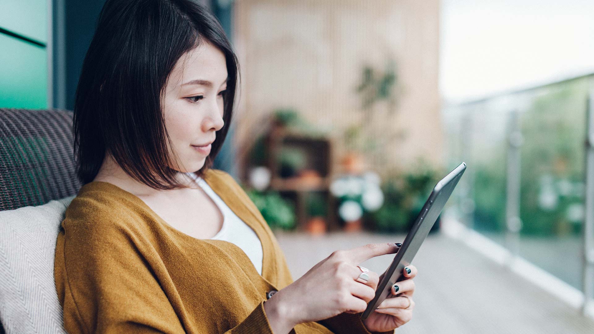 Asian woman reading work email on digital tablet outdoor