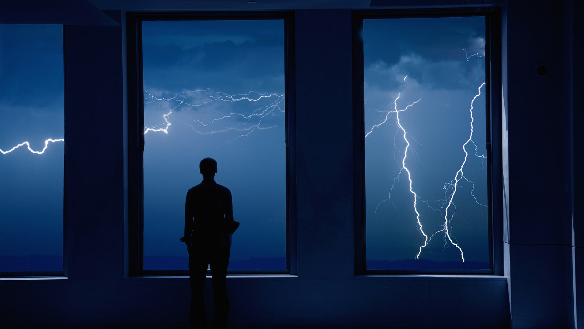 Man in rain and lightning with umbrella