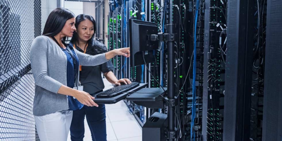 Two women assessing data centre server racks