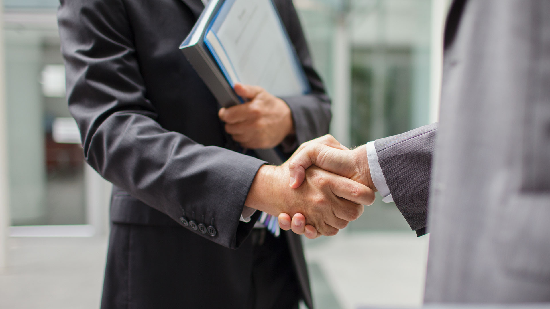 Businessmen shaking hands outdoors