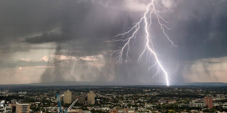 Aerial view of lightning over a city at night, weather.