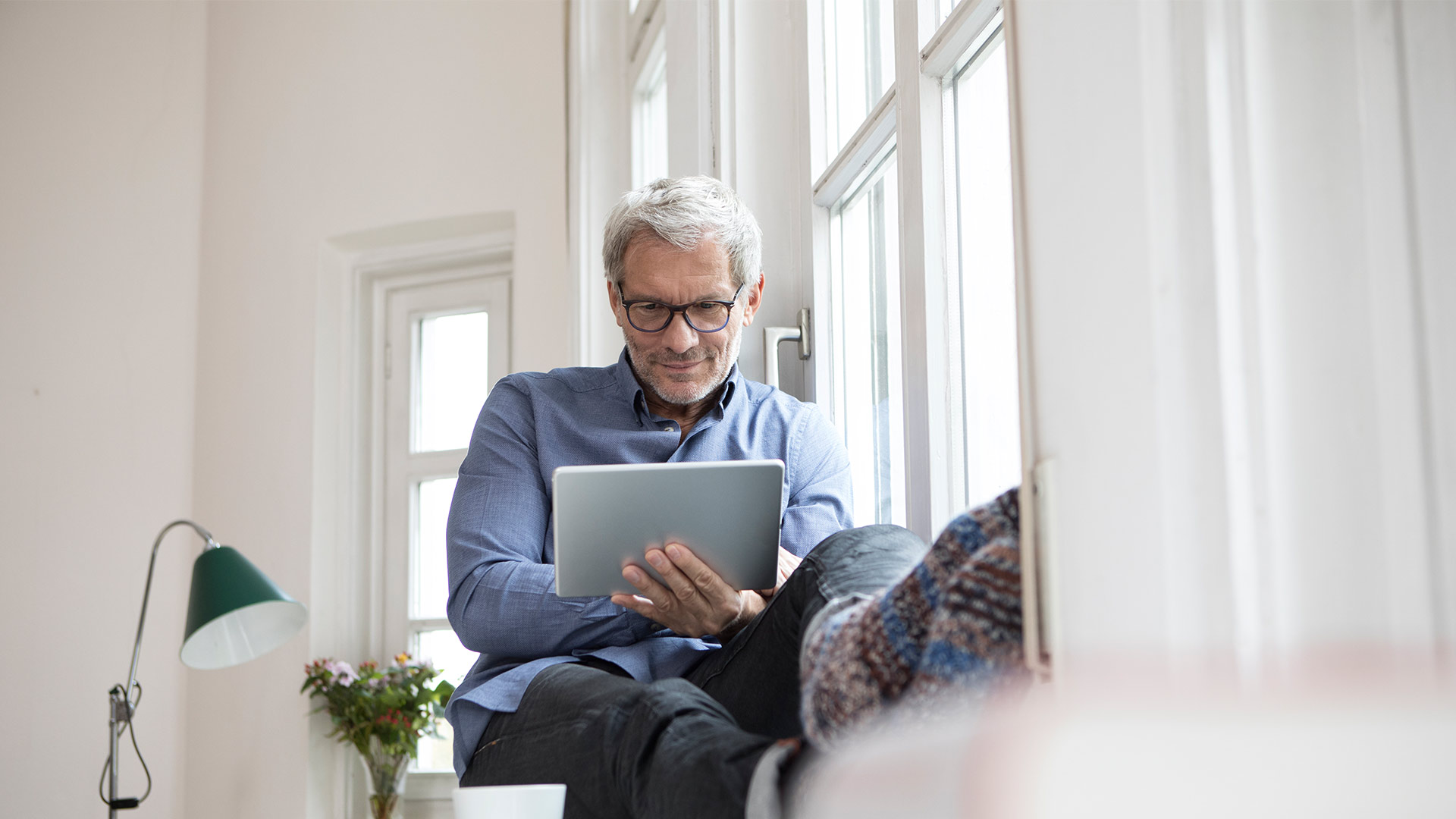 A man watching something in tablet at home