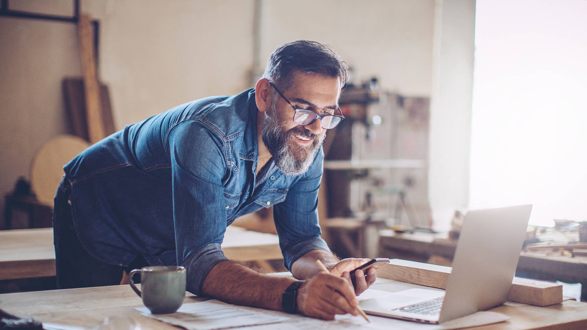 man sitting at his desk working on his laptop