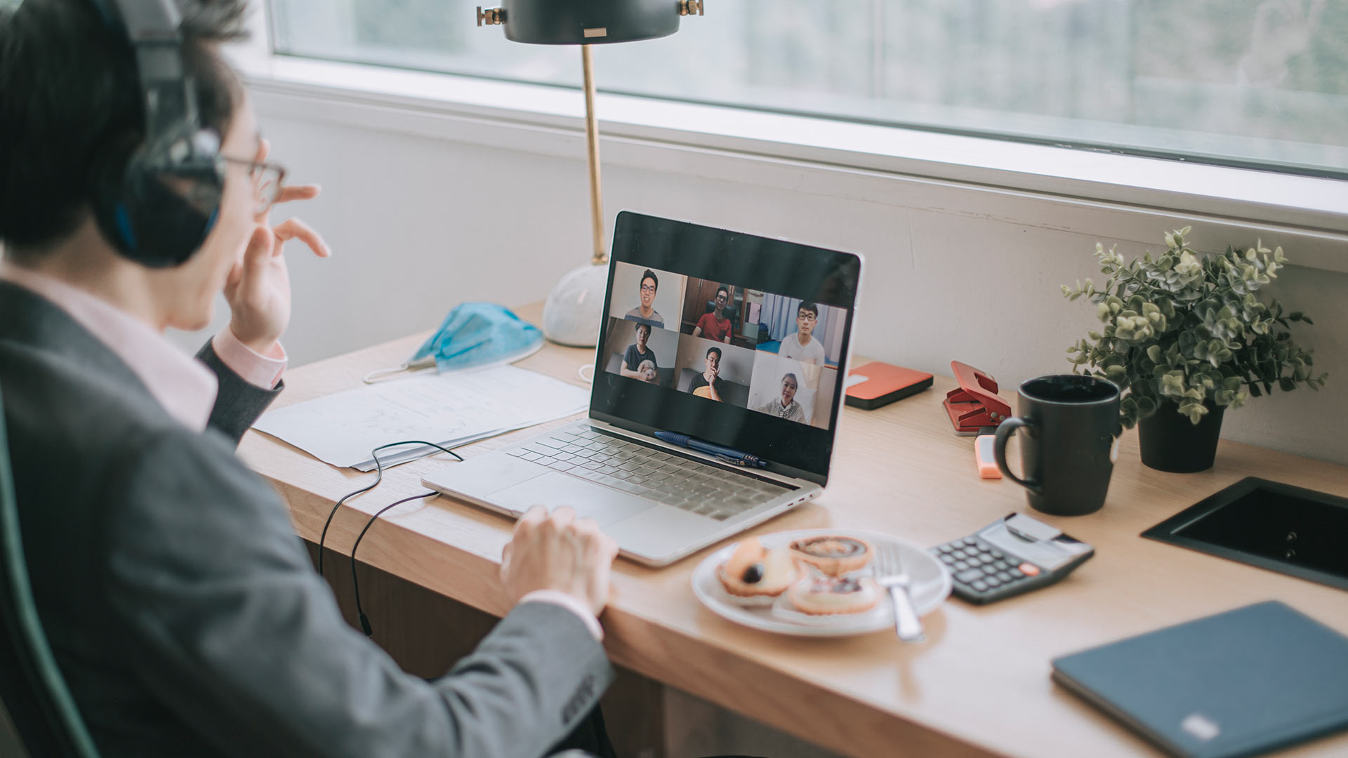 A man attending group meeting through his laptop