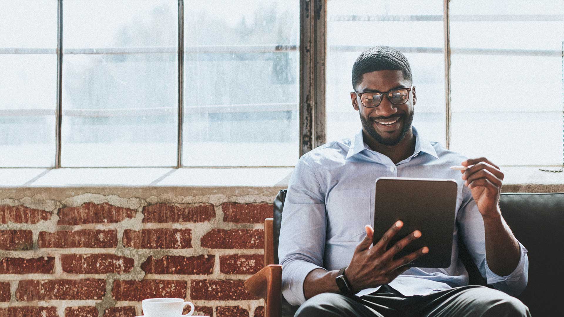 Man sitting on beach and using digital tablet