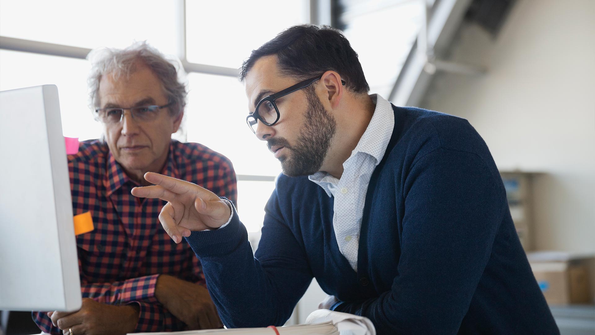 Employee showing his boss a project on his computer