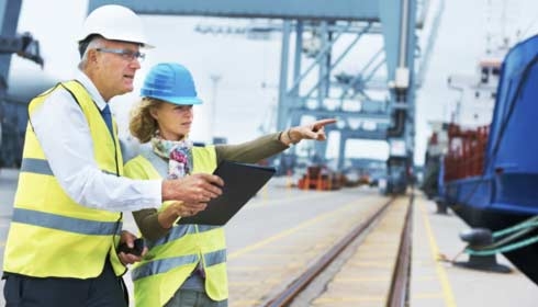 Two project managers discussing modification in a shipyard environment.