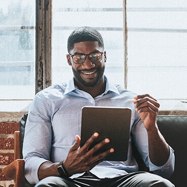 Man looking at a tablet and smiling