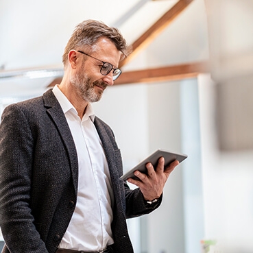 Employee looking in to his tablet and smiling