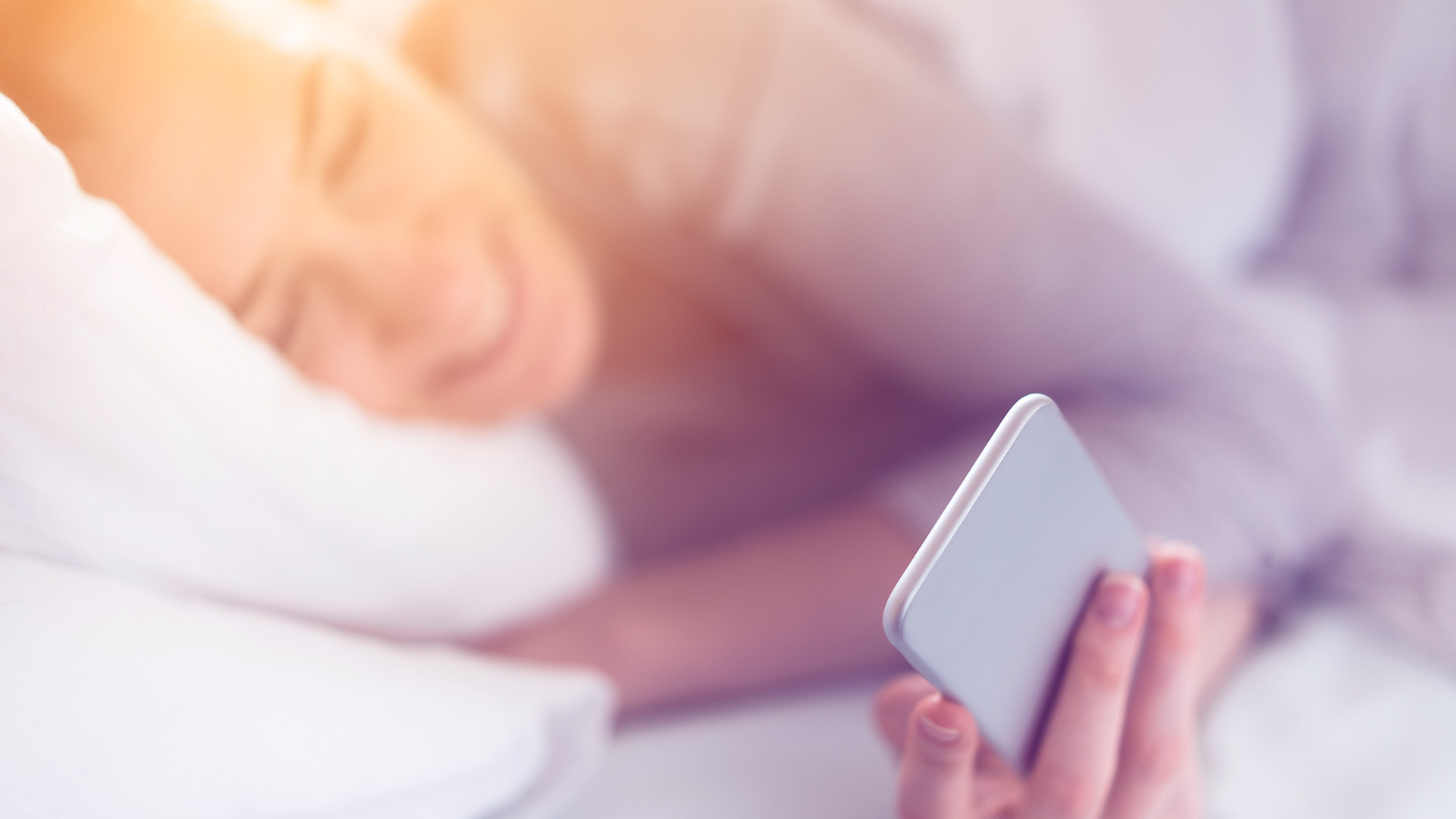 Woman checking her social media in bed