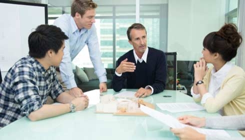 A manager having a team meeting with his employees, cloud service providers
